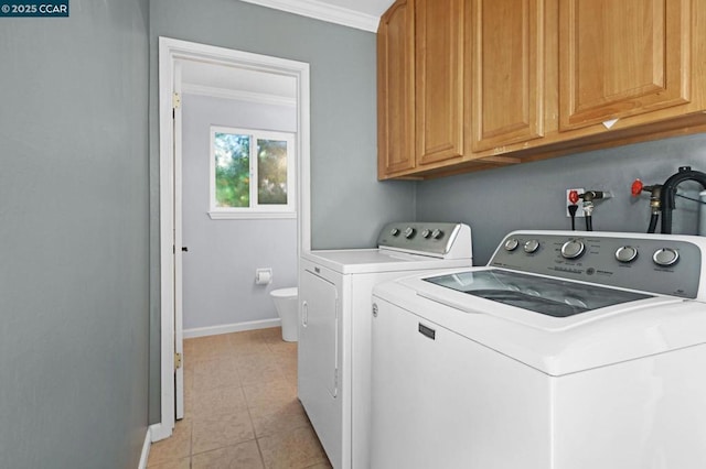 clothes washing area featuring cabinets, light tile patterned floors, crown molding, and washing machine and clothes dryer