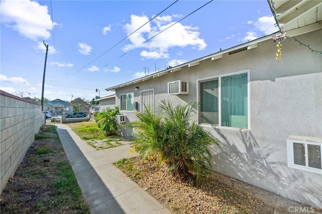 view of side of home featuring a wall mounted air conditioner