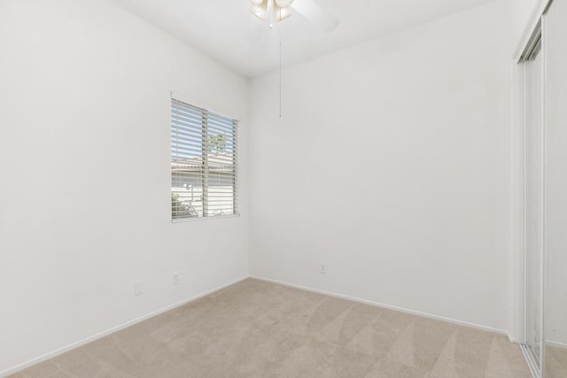 carpeted spare room featuring ceiling fan