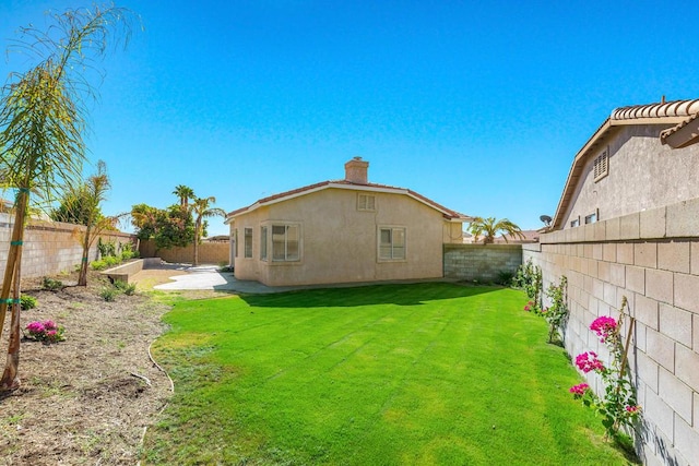 rear view of house featuring a yard and a patio