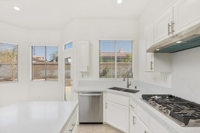 kitchen with light tile patterned floors, sink, stainless steel appliances, and white cabinetry