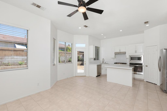 kitchen featuring a center island, sink, plenty of natural light, stainless steel appliances, and white cabinets