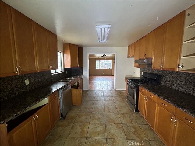 kitchen featuring ceiling fan, dark stone countertops, tasteful backsplash, and stainless steel appliances