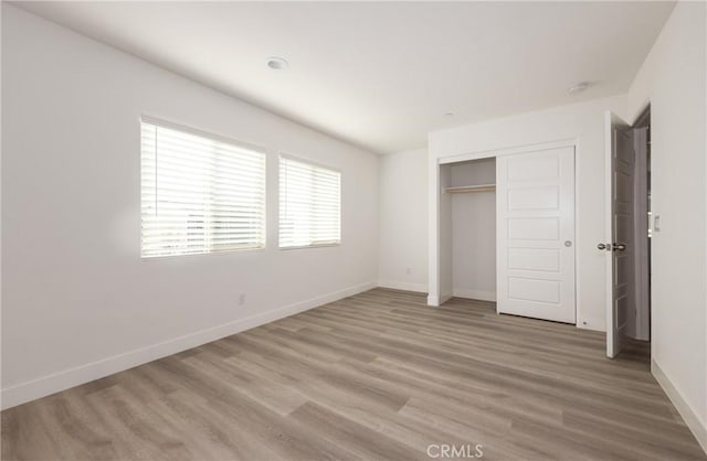 unfurnished bedroom with hardwood / wood-style floors and a closet