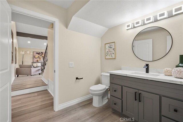 bathroom featuring toilet, vanity, and hardwood / wood-style flooring