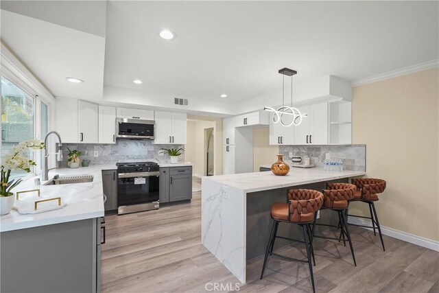 kitchen with white cabinets, stainless steel appliances, sink, hanging light fixtures, and gray cabinets