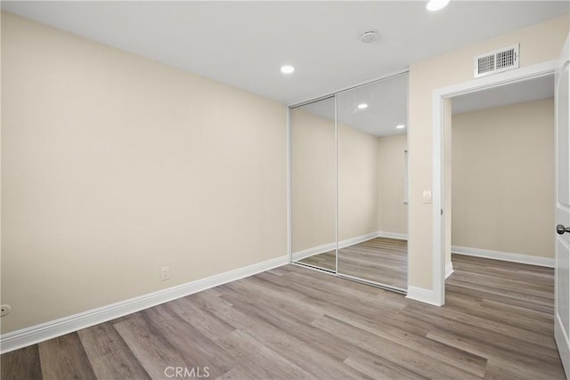 unfurnished bedroom with a closet and hardwood / wood-style floors