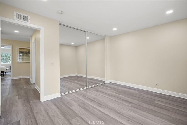 unfurnished bedroom with a closet and light hardwood / wood-style floors