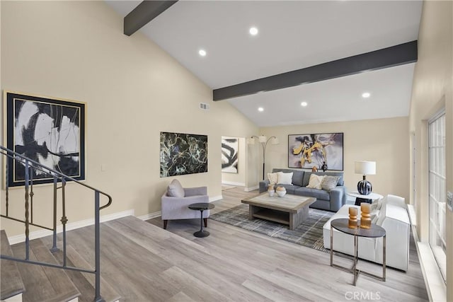 living room with beam ceiling, light hardwood / wood-style flooring, and high vaulted ceiling