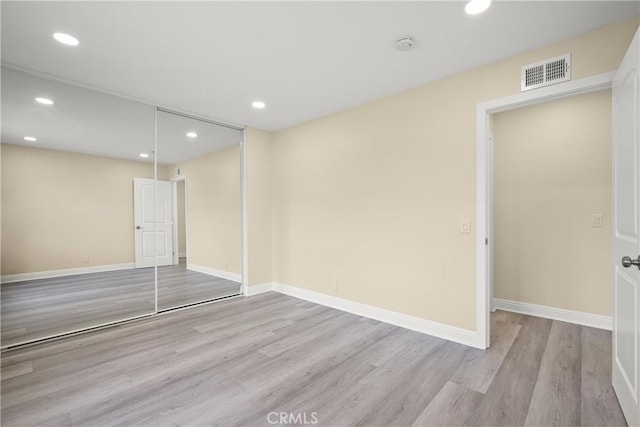 unfurnished bedroom featuring a closet and light hardwood / wood-style flooring