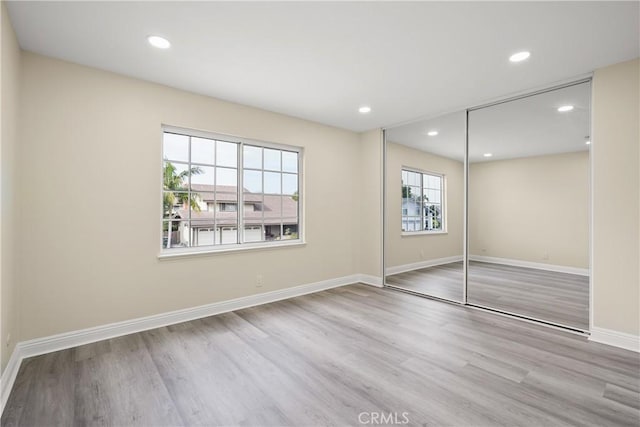 unfurnished bedroom with a closet and light hardwood / wood-style flooring