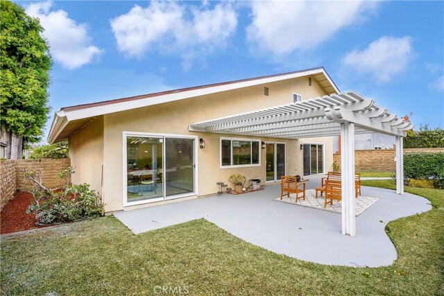 rear view of property featuring a pergola, a yard, and a patio