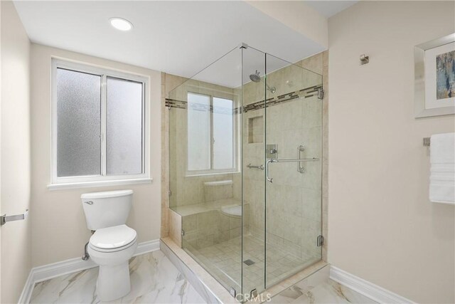 bathroom featuring toilet and a shower with shower door