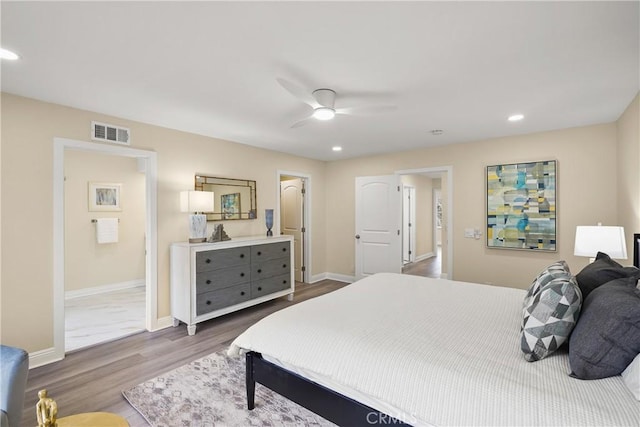 bedroom featuring ceiling fan, wood-type flooring, and ensuite bath