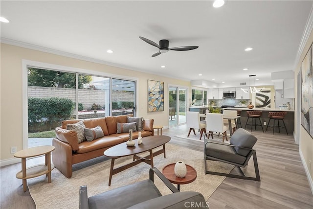 living room with ceiling fan, light hardwood / wood-style flooring, and crown molding