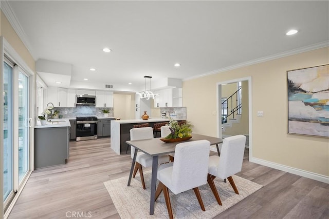 dining area featuring a healthy amount of sunlight, light wood-type flooring, and crown molding