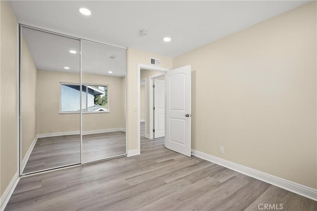 unfurnished bedroom featuring a closet and light hardwood / wood-style floors