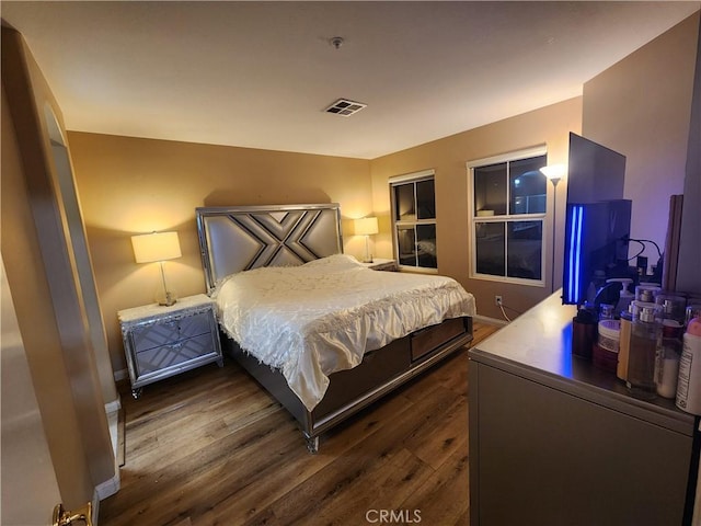 bedroom with dark hardwood / wood-style floors