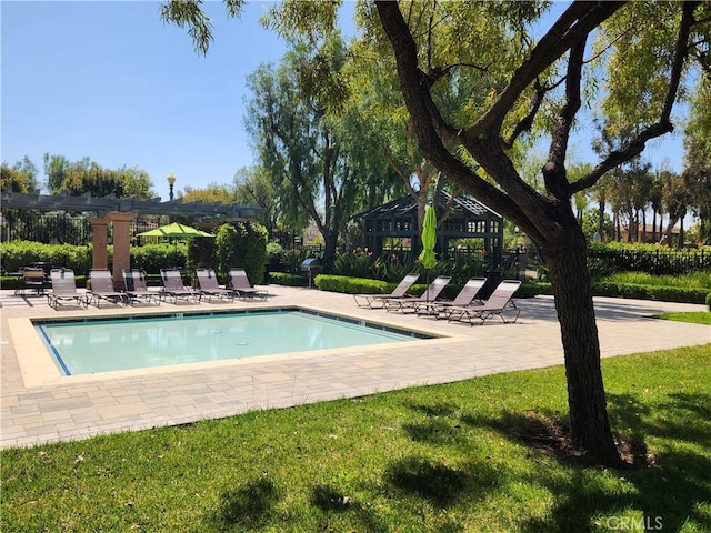 view of pool featuring a pergola, a patio area, and a lawn