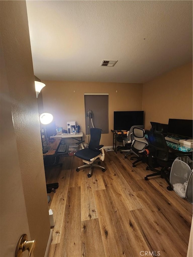 home office featuring hardwood / wood-style flooring and a textured ceiling