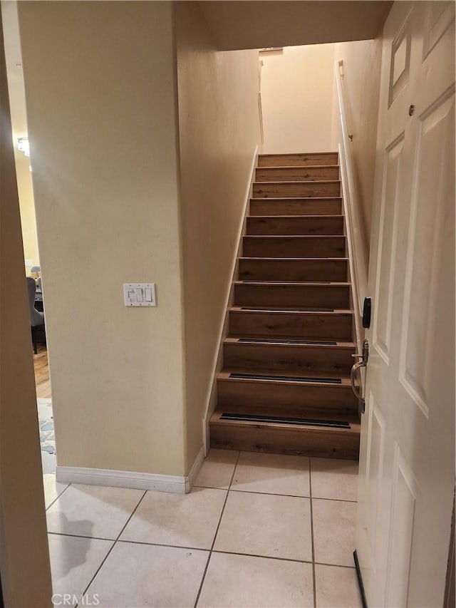 stairway featuring tile patterned flooring