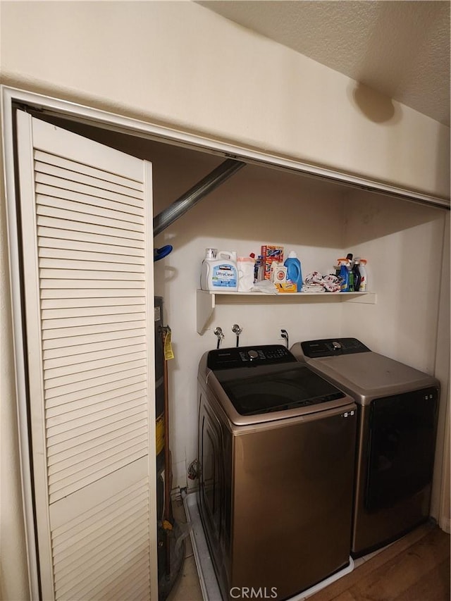 washroom with washing machine and clothes dryer and a textured ceiling