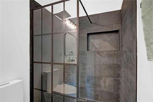 bathroom featuring toilet and a tile shower