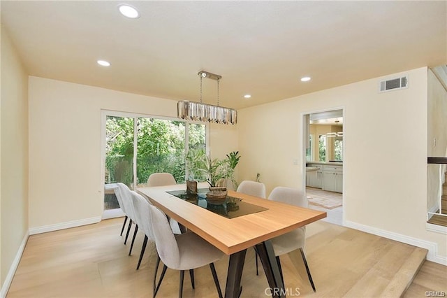 dining room with a notable chandelier and light hardwood / wood-style floors