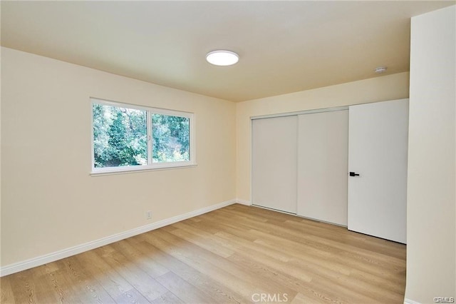 unfurnished bedroom featuring a closet and light hardwood / wood-style floors