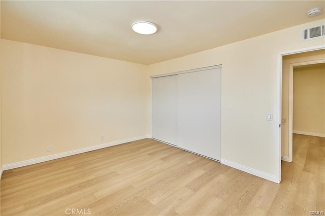 unfurnished bedroom featuring light wood-type flooring and a closet