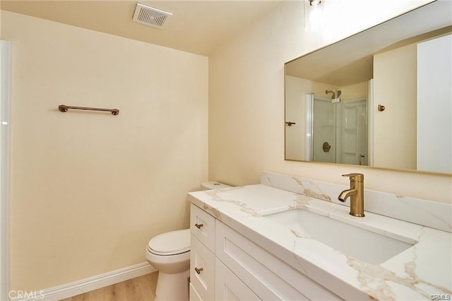 bathroom with toilet, vanity, a shower with door, and hardwood / wood-style flooring