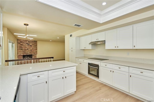 kitchen featuring a brick fireplace, white cabinetry, and black appliances