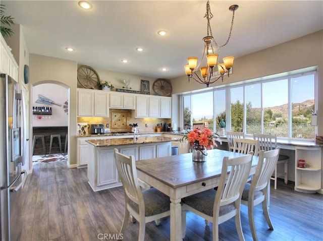 dining space featuring a mountain view, a wealth of natural light, dark hardwood / wood-style floors, and a chandelier