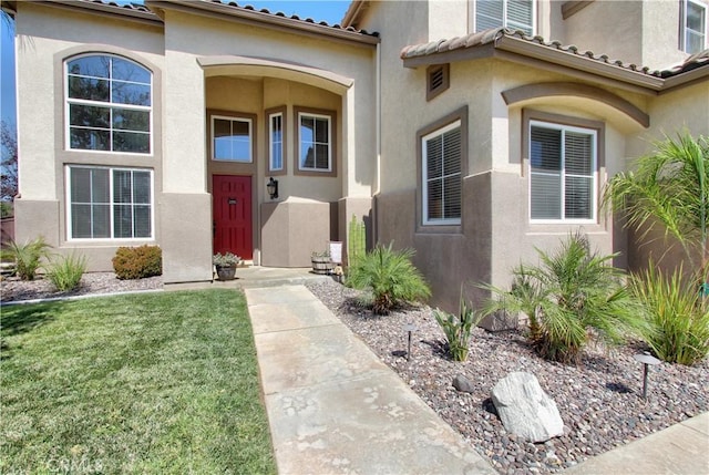 doorway to property featuring a lawn