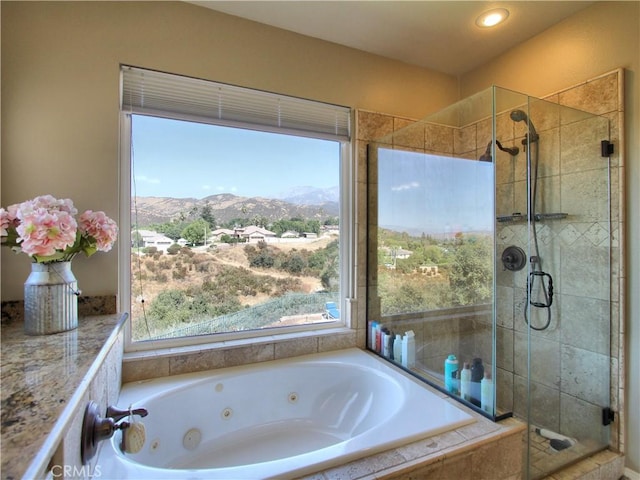 bathroom featuring independent shower and bath and a mountain view