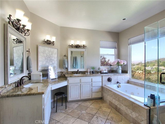 bathroom with tiled tub and vanity