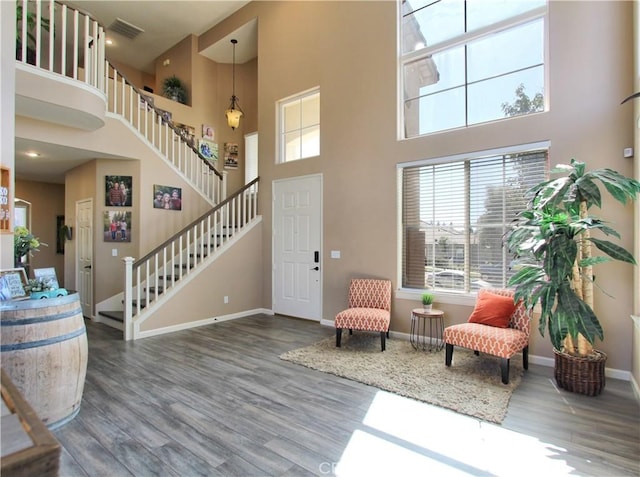 living area featuring a high ceiling and hardwood / wood-style floors