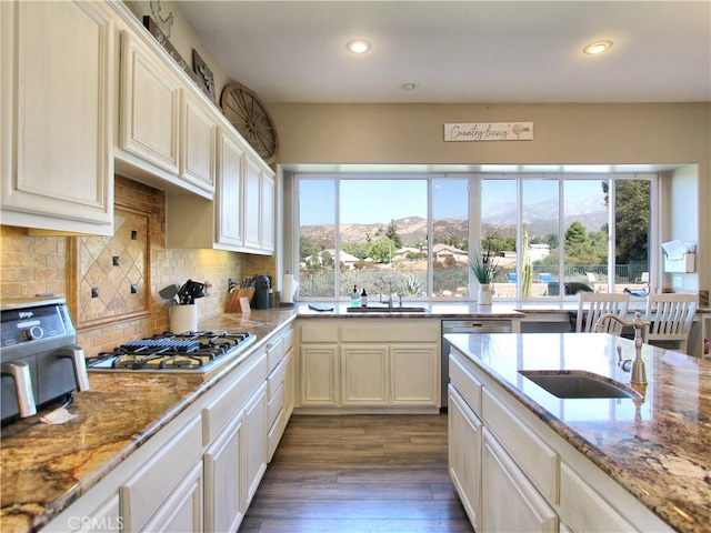 kitchen with a mountain view, light stone countertops, appliances with stainless steel finishes, and tasteful backsplash