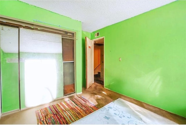 unfurnished bedroom featuring a closet and a textured ceiling