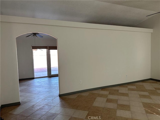 tiled spare room featuring ceiling fan and vaulted ceiling