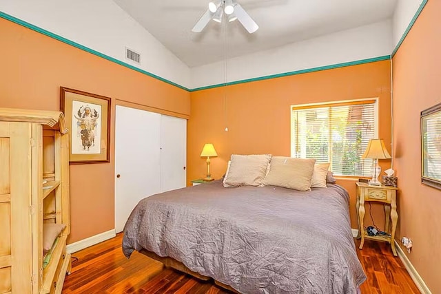 bedroom featuring ceiling fan, a closet, dark wood-type flooring, and vaulted ceiling