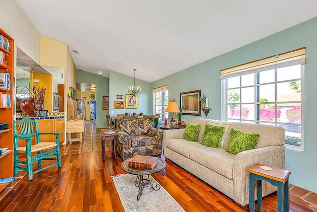 living room featuring an inviting chandelier, lofted ceiling, and hardwood / wood-style floors