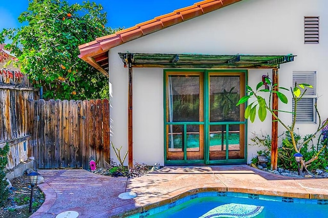 view of exterior entry with a fenced in pool