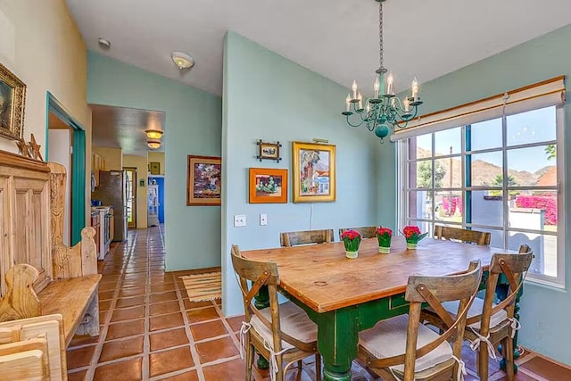 tiled dining area with vaulted ceiling, plenty of natural light, a mountain view, and a chandelier