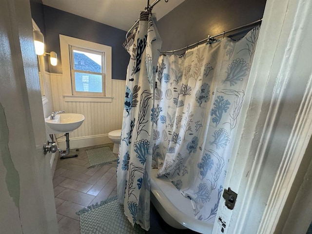 bathroom with toilet, tile patterned flooring, and shower / bath combo with shower curtain