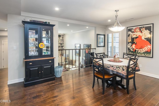 dining area with dark wood-type flooring and built in features