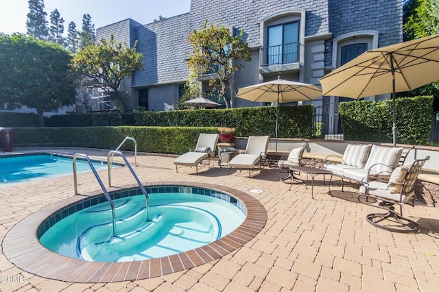 view of swimming pool featuring a patio area and a hot tub