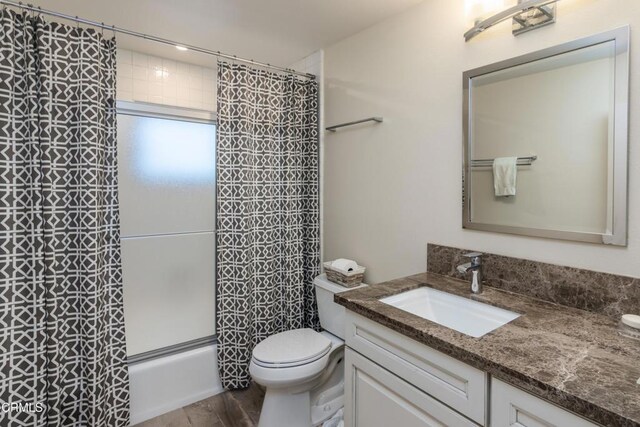 full bathroom featuring hardwood / wood-style flooring, toilet, vanity, and shower / bathtub combination with curtain