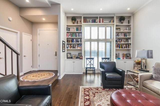 living room with built in shelves, dark hardwood / wood-style floors, and ornamental molding