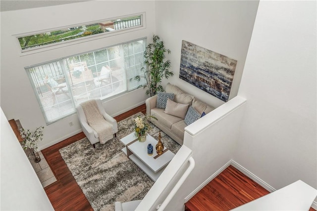 sitting room featuring a towering ceiling and hardwood / wood-style flooring